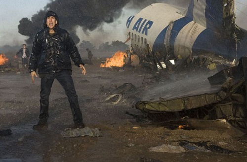 Nicolas Cage in front of a crashed plane